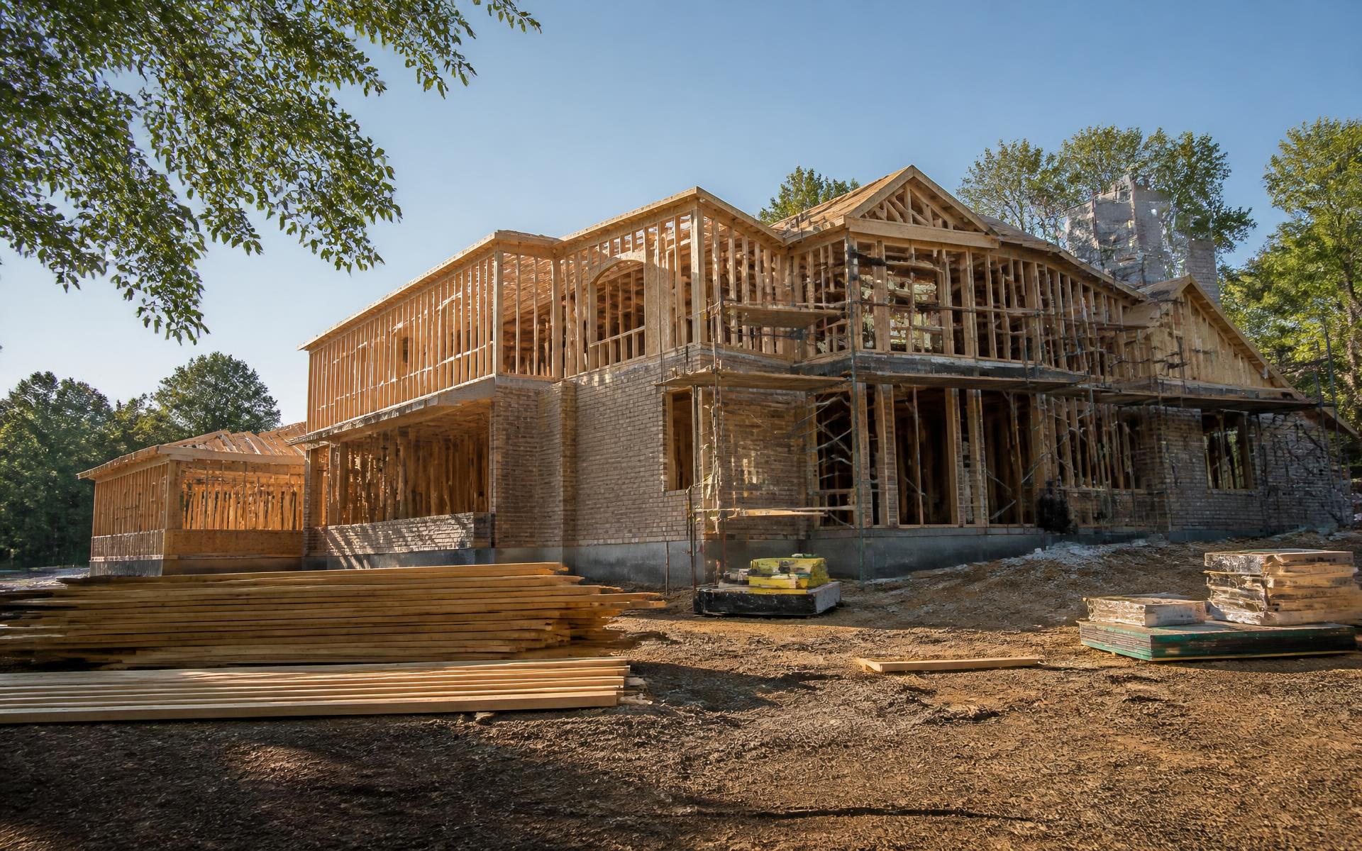 Custom home under construction with timber framing and brick veneer in Charlotte