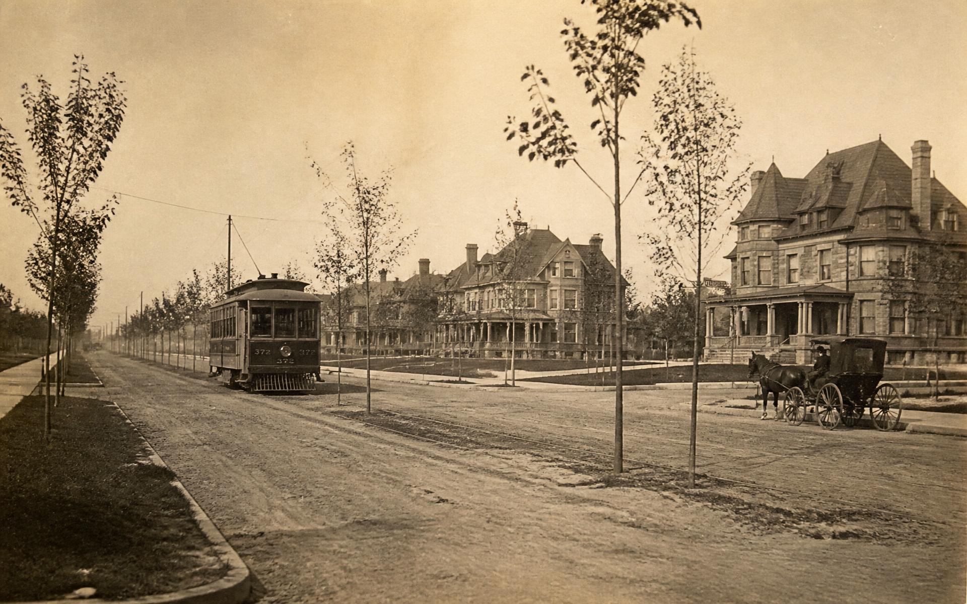 Archival-style view of an early streetcar on a tree-lined Charlotte avenue